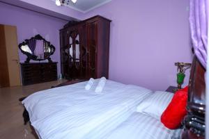 - une chambre avec un lit blanc, une commode et un miroir dans l'établissement Rio's Apartment, à Berat