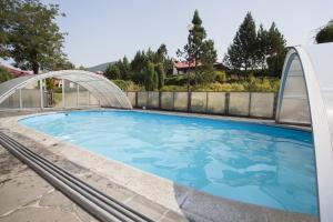 a large swimming pool with a bridge over it at Relaks Domki pod Górą Żar in Międzybrodzie Żywieckie