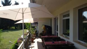 patio z krzesłami i parasolem na domu w obiekcie Hotel Schlossgarten w mieście Gladenbach