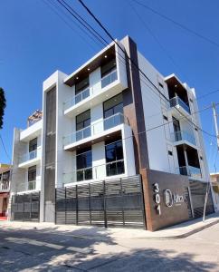 a white building with a sign in front of it at Confortable Departamento in Mazatlán