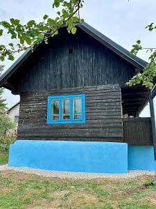 a building with a blue window on the side of it at Chata Bottka in Šumiac
