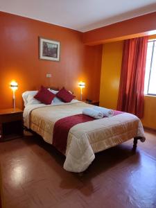 a bedroom with a large bed with orange walls at Krusty Hostel B&B in Huaraz