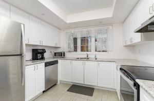a white kitchen with white cabinets and appliances at 4 Bedroom Oshawa house in Oshawa