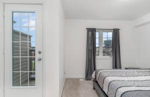 a bedroom with a bed and a window at 4 Bedroom Oshawa house in Oshawa