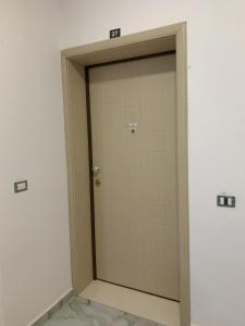 uma porta de madeira num quarto branco com em DESA Seaside Apartment em Vlorë