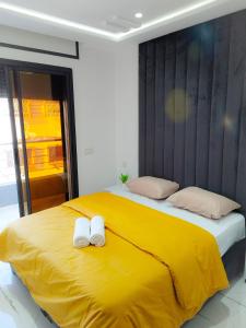 una camera con letto giallo e 2 cuscini bianchi di les Belles Résidences de Safir a Tangeri