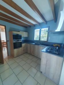 a large kitchen with blue walls and a counter top at Charmante maison proche plage - 5242 in Soulac-sur-Mer