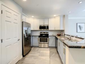 a kitchen with white cabinets and stainless steel appliances at MINUTES FROM DISNEY 3bed 3bath Poolside at LUXURIOUS RESORT in Kissimmee