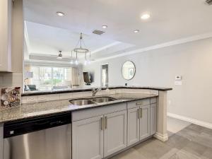 a large kitchen with a sink and a mirror at MINUTES FROM DISNEY 3bed 3bath Poolside at LUXURIOUS RESORT in Kissimmee