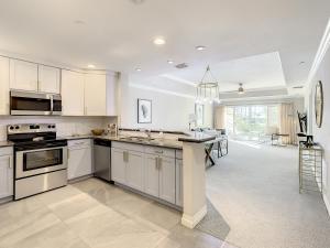 a large kitchen with white cabinets and a kitchen island at MINUTES FROM DISNEY 3bed 3bath Poolside at LUXURIOUS RESORT in Kissimmee