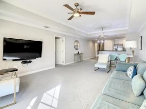 a living room with a blue couch and a flat screen tv at MINUTES FROM DISNEY 3bed 3bath Poolside at LUXURIOUS RESORT in Kissimmee
