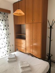 een slaapkamer met een bed en een houten kast bij Blue Sky Apartments I in Makry Gialos