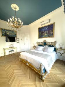 a bedroom with a large bed and a chandelier at Stile Libero Guest House in Turin