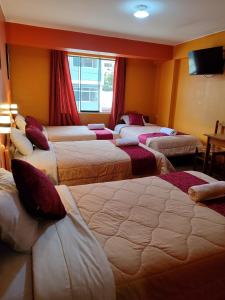 Habitación de hotel con 4 camas seguidas en Krusty Hostel B&B, en Huaraz