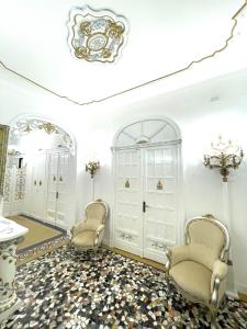 都靈的住宿－Stile Libero Guest House，客厅配有两把椅子和吊灯