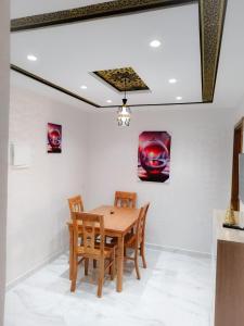 - une salle à manger avec une table et des chaises en bois dans l'établissement les Belles Résidences de Safir, à Tanger