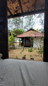 a room with a window looking at a small house at Rumah Seraya@Zaki’s Residence, Marang, Terengganu in Marang