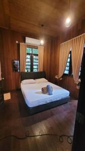 a bedroom with a bed with a teddy bear on it at Rumah Seraya@Zaki’s Residence, Marang, Terengganu in Marang