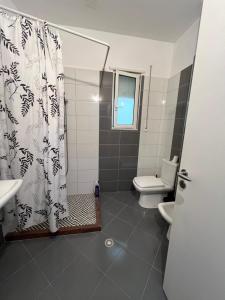 uma casa de banho com uma cortina de chuveiro e um WC em DESA Seaside Apartment em Vlorë