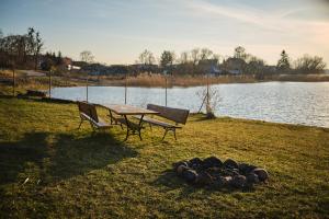 イワヴァにあるZ widokiem na jezioroのピクニックテーブル、キャンプファイヤーの横に座る椅子2脚