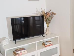 a flat screen tv sitting on a white entertainment center at Modern Studio near Düsseldorf Airport & Messe/Fair in Meerbusch