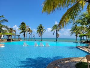 uma piscina com cadeiras e palmeiras na praia em Wai Wai Cumbuco Eco Residence - Bahamas 101 em Cumbuco