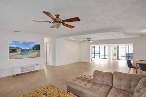 a living room with a couch and a ceiling fan at Stylish palm beach home with pool and office in Palm Beach Gardens
