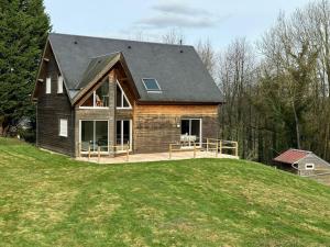 a house on top of a grassy hill at La Maison Verte in Clécy