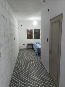 a hallway with a room with a bed and a door at Monoambientes Chamical in Chamical