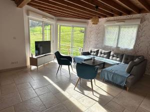 a living room with a couch and a table at La Maison Verte in Clécy