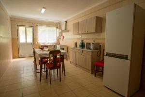 a kitchen with a table and chairs and a refrigerator at Casa da Carmita in Angra do Heroísmo