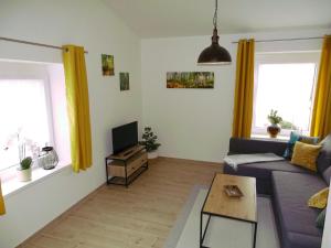 a living room with a couch and a tv at Ferienwohnung Schusternagerl in Simbach