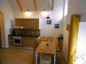 a kitchen with a table and chairs in a room at Ferienwohnung Schusternagerl in Simbach