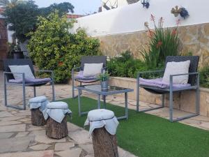 een patio met 3 stoelen, een tafel en bomen bij LA LLAR DE LAURA 2 in Amposta