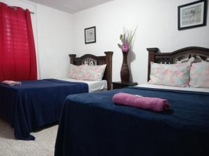 Habitación con 2 camas y sábanas azules y rosas. en Historico maya, en Guatemala