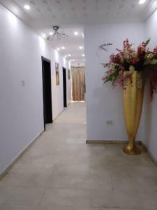 a hallway with a large vase with flowers in it at Zek’s Place in Ikeja