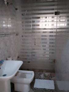 a bathroom with a white toilet and a sink at Zek’s Place in Ikeja