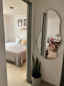 - une chambre avec un lit et un miroir mural dans l'établissement Casa Bohemia, à Ciudad Guzmán