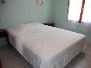 uma cama branca num quarto com uma janela em Villa dans quartier résidentiel - V06493 em Soulac-sur-Mer