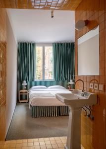 een slaapkamer met een bed, een wastafel en een raam bij Armesto Rooms in Madrid