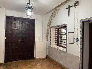 un pasillo con dos puertas marrones y una cruz en la pared en Apartamentos San Francisco, en Sevilla