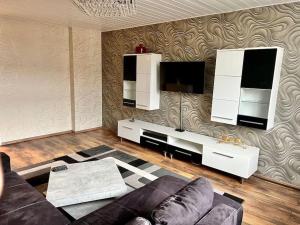 een woonkamer met een bank en een flatscreen-tv bij Wohnung im Zentrum 70 qm in Hof