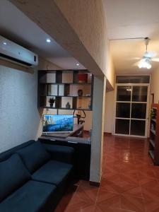 a living room with a couch and a laptop on a desk at Residencia Dos Soles -Resistencia Chaco in Resistencia