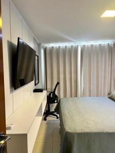 a bedroom with a bed and a flat screen tv at APART HOTEL MANAÍRA PALACE in João Pessoa