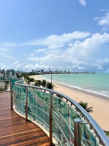 a boardwalk leading to a beach and the ocean at APART HOTEL MANAÍRA PALACE in João Pessoa
