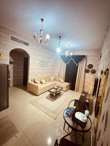 ein Wohnzimmer mit einem Sofa und einem Tisch in der Unterkunft Beautiful home in Ajman 
