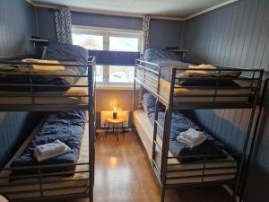 two bunk beds in a room with a window at Semi-detached house downtown in Tromsø