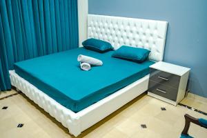 a blue bedroom with a bed with blue pillows at COMFORT HOME in Gujrāt