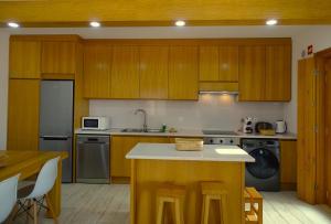 SWEET HOME MILFONTES by Stay in Alentejo في فيلا نوفا دو ميلفونتيس: مطبخ بدولاب خشبي وقمة كونتر