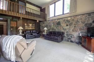 1 dormitorio con pared de piedra, sofá y sillas en The Retreat, 